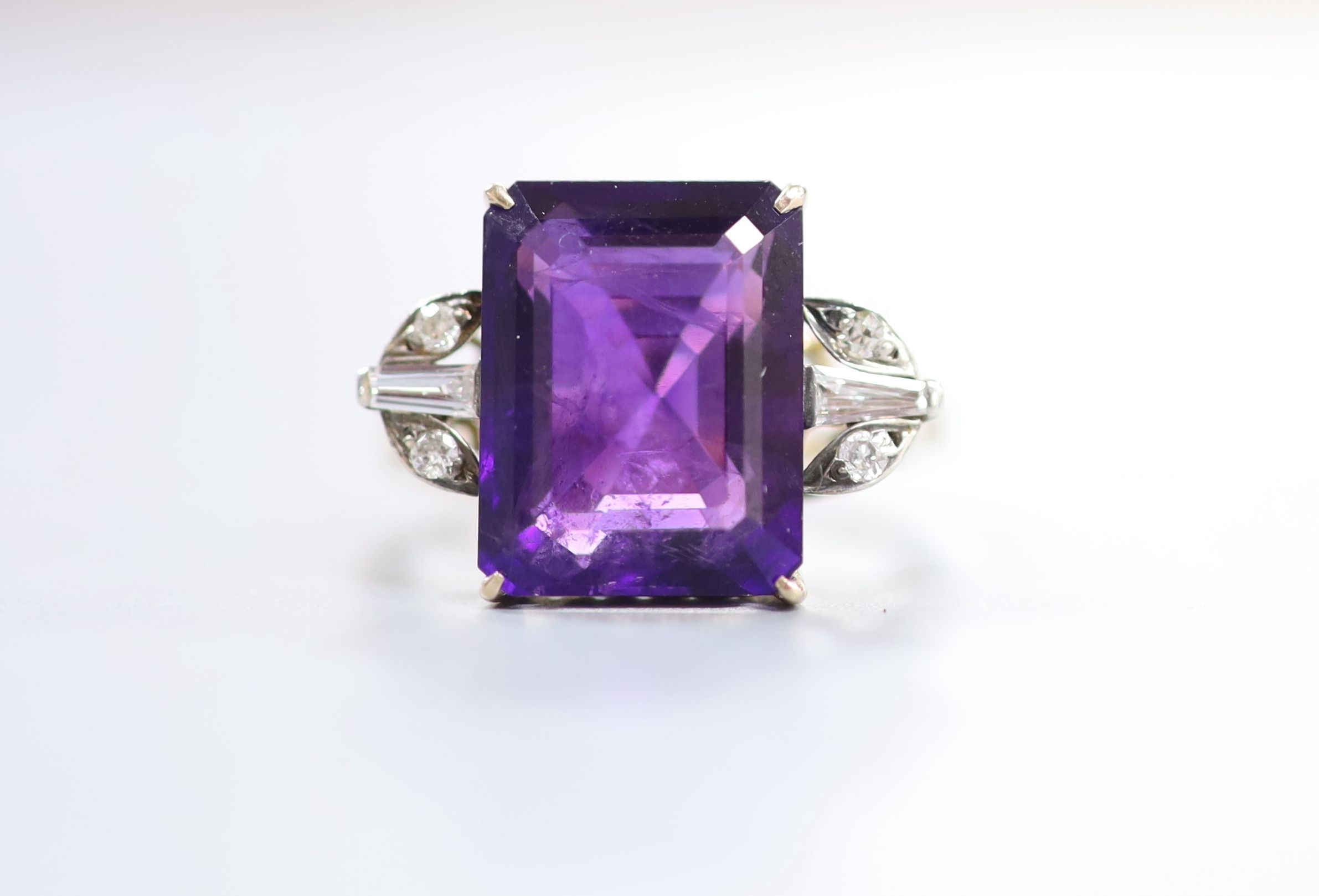 A yellow metal and single stone emerald cut amethyst dress ring, with trapeze and round cut diamond set shoulders, size P, gross weight 6.1 grams.